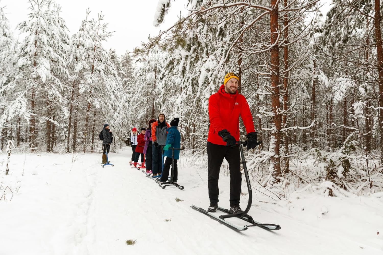 Tiim tõukekelkudel rivis, giid eesotsas