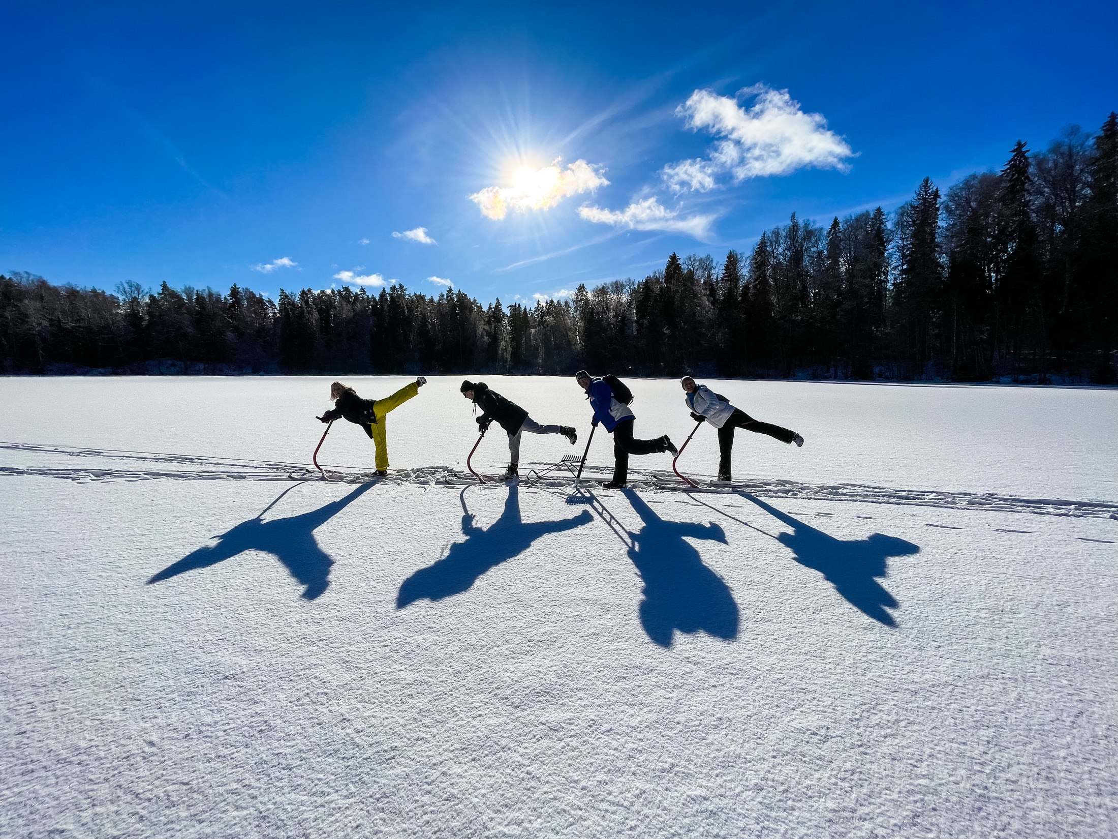 Neli matkauisutajat päikeselisel järvel